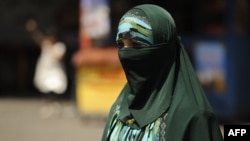 A Uyghur woman walks on a street in Urumqi, the capital of China's Xinjiang region. (file photo)