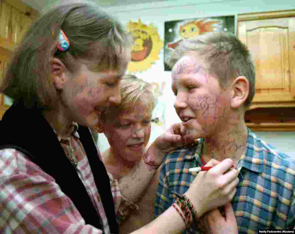 Friends scrawl messages onto each other during the final day of a health camp for children near Minsk.