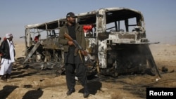 A Pakistani paramilitary soldier stands guard at the site of the bus bombing in Balochistan on December 30.