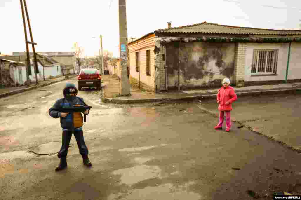 Спустя год после аннексии Крыма дети играют в &laquo;зеленых человечков&raquo;. Говорят, что могут и &laquo;прическу под террористов сделать если надо&raquo;. Симферополь, старый город. 20 марта 2015 года