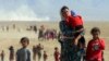 Displaced people from the minority Kurdish Yazidi sect flee forces loyal to the Islamic State in Sinjar in northern Iraq in August.