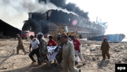 Pakistan -- Pakistani security officials carry the body of a victim who was killed after an explosion at the Gadani ship-breaking yard, November 1, 2016