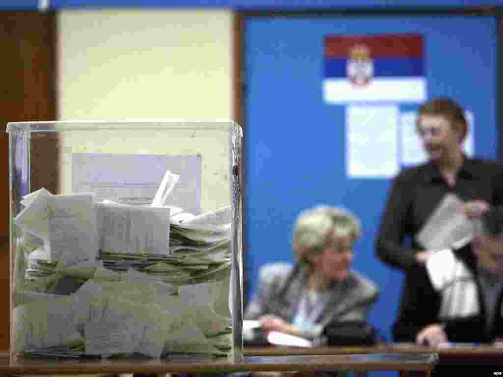 Caption: epa01228546 Electorial staff in background check lists of voters at the polling station during the presidential elections in Belgrade, Serbia, 20 January 2008.