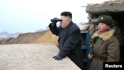Солтүстік Корея басшысы Ким Чен Ын дүрбімен қарап тұр. 7 наурыз 2013 жыл