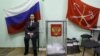 A police officer sits next to a ballot box at a polling station in St. Petersburg on March 4. The OSCE says the vote count was faulty in almost one-third of the polling stations observed.