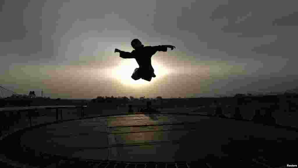 A boy is silhouetted against the sun while jumping on a trampoline on the outskirts of the Pakistani capital, Islamabad. (Reuters/Faisal Mahmood)