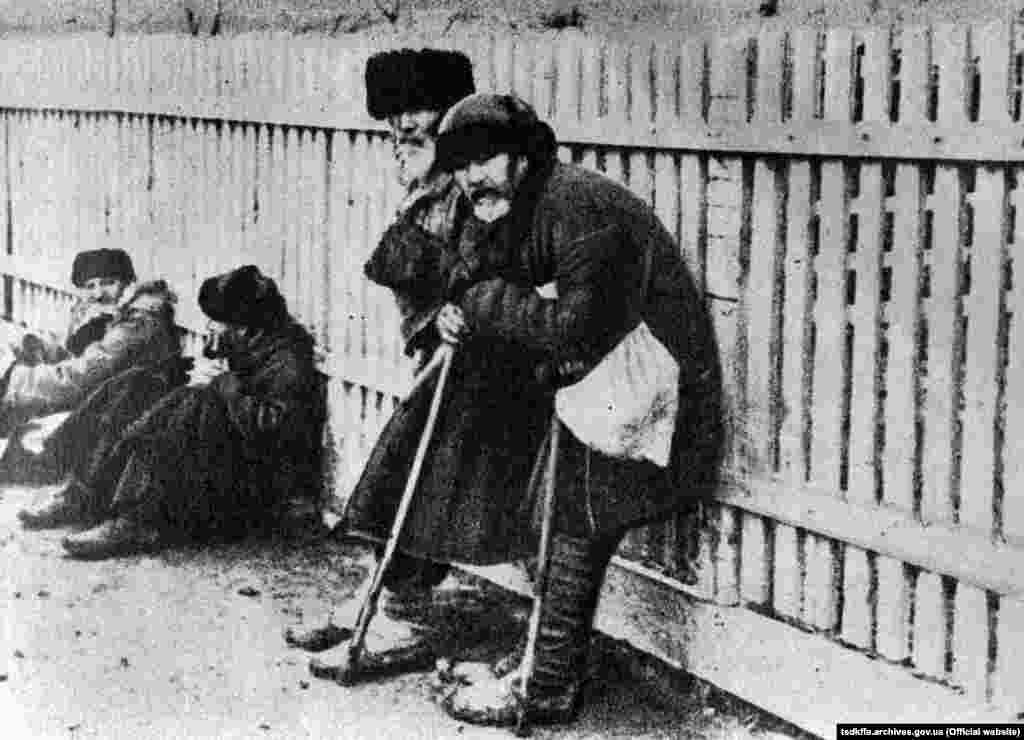 Голодні люди стоять під парканом. Місце і дата зйомки: УССР, 1932-1933 рр