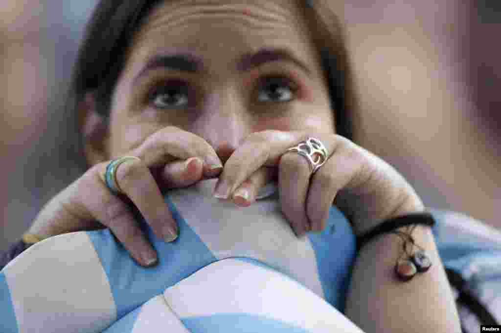 Brazil -- An Argentina fan crosses her fingers as she watches a broadcast of the 2014 World Cup final against Germany at the Argentine Embassy in Brasilia, July 13, 2014.