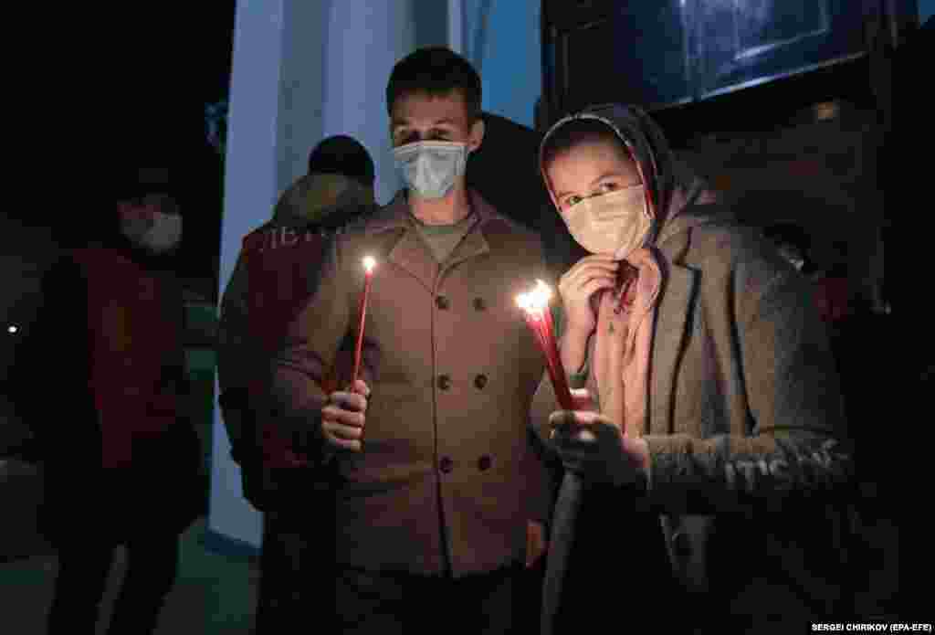 Russian Orthodox believers hold candles during Easter Sunday celebrations in Moscow on April 19. Russian churches held services but restricted the number of believers due to the coronavirus epidemic. 