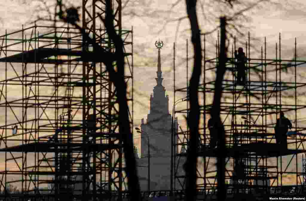 Construction workers are seen on scaffolding in the Russian capital with the Moscow State University building in the background. (Reuters/Maxim Shemetov)