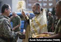 Священник благословляет российского полковника Игоря Гиркина (Стрелкова), который в то время был одним из главарей группировки "ДНР", которая в Украине признана террористической. Оккупированный Донецк, 10 июля 2014 года