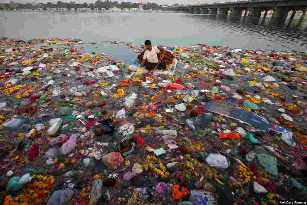 A man collects items thrown as offerings by worshippers into the Sabarmati River, a day after the immersion of idols of the Hindu god Ganesh, the deity of prosperity, in Ahmedabad, India. (Reuters/Amit Dave)