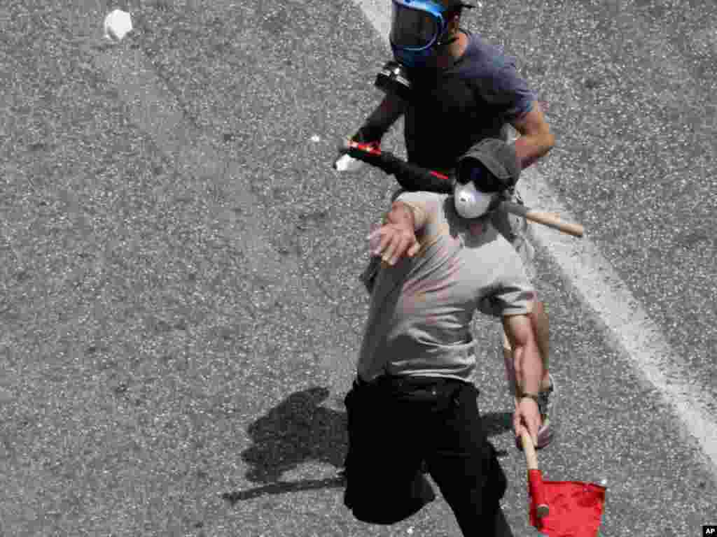 Demonstrators throw stones at police during a protest against austerity reforms in Athens on June 28. Photo by Dimitri Messinis for AP