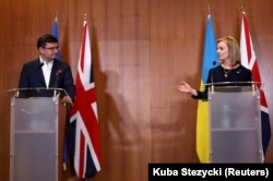 Ministrul de Externe al Ucrainei, Dmitro Kuleba (stânga), alături de Liz Truss, în timpul unei conferințe de presă de la ambasada Marii Britanii din Varșovia, Polonia. Fotografie realizată la data de 4 aprilie 2022.