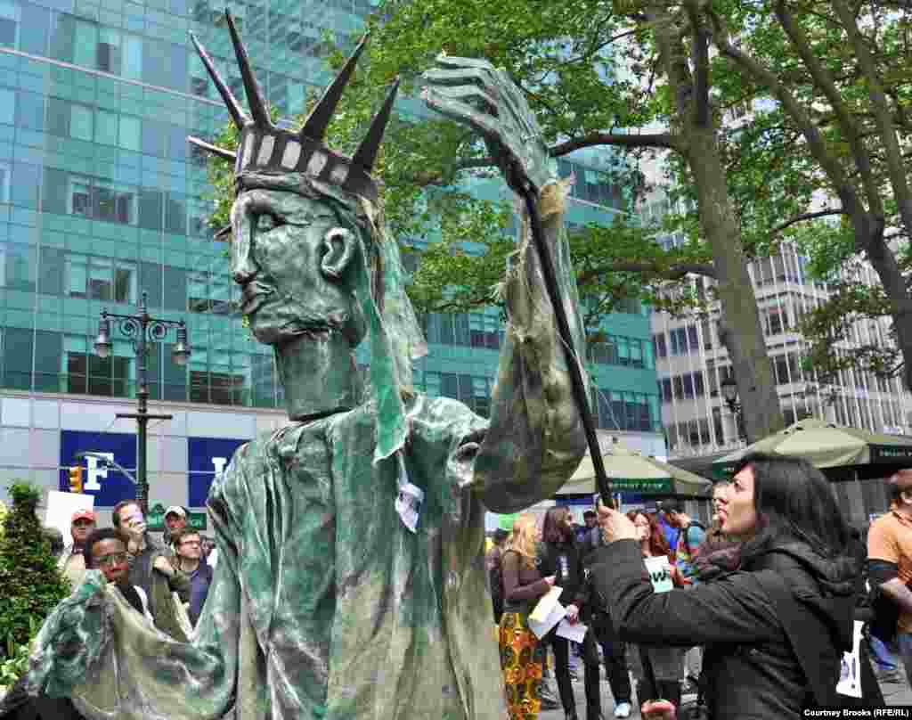 Three OWS activists make a papier-mache Statue of Liberty dance to music.