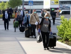 Romanian care workers accompanied by police and security arrive at the train station of Vienna's airport on May 11.