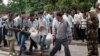 Local residents carry the body of a victim of the clashes between government forces and local protesters at the central square in the Uzbek town of Andijon on May 14, 2005.