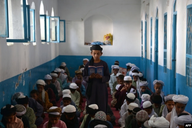 Disa nxënës duke lexuar Kuranin në një medrese.