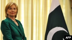U.S. Secretary of State Hillary Clinton stands next to a Pakistani flag during a recent visit to Pakistan.