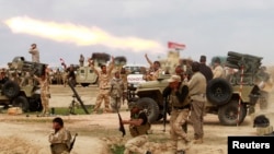 Shi'ite fighters launch a rocket toward Islamic State militants during heavy fighting in Salah al-Din Province on March 4.