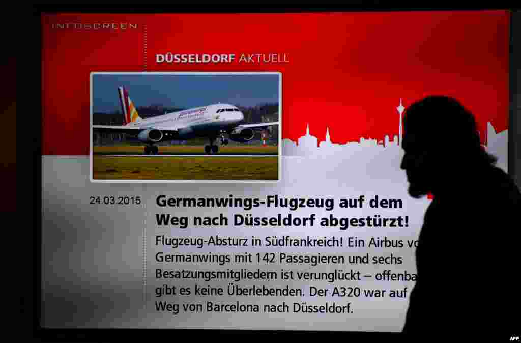 Njemačka, čovjek prolazi ispred ekrana na kojem se prikazuju vijesti o padu aviona, 24. mart 2015. godine.