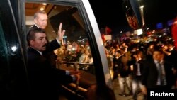 Turkish Prime Minister Recep Tayyip Erdogan (2nd left) waves to supporters after arriving at Istanbul's Ataturk Airport early on June 7.