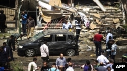 People gather at the site of a bomb that targeted the convoy of Egyptian Interior Minister Muhammad Ibrahim in Cairo.
