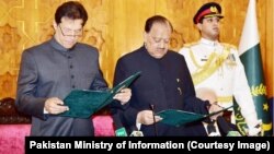 Imran Khan (left) takes the oath of office as Pakistani prime minister with President Mamnoon Hussain in attendance on August 18. 