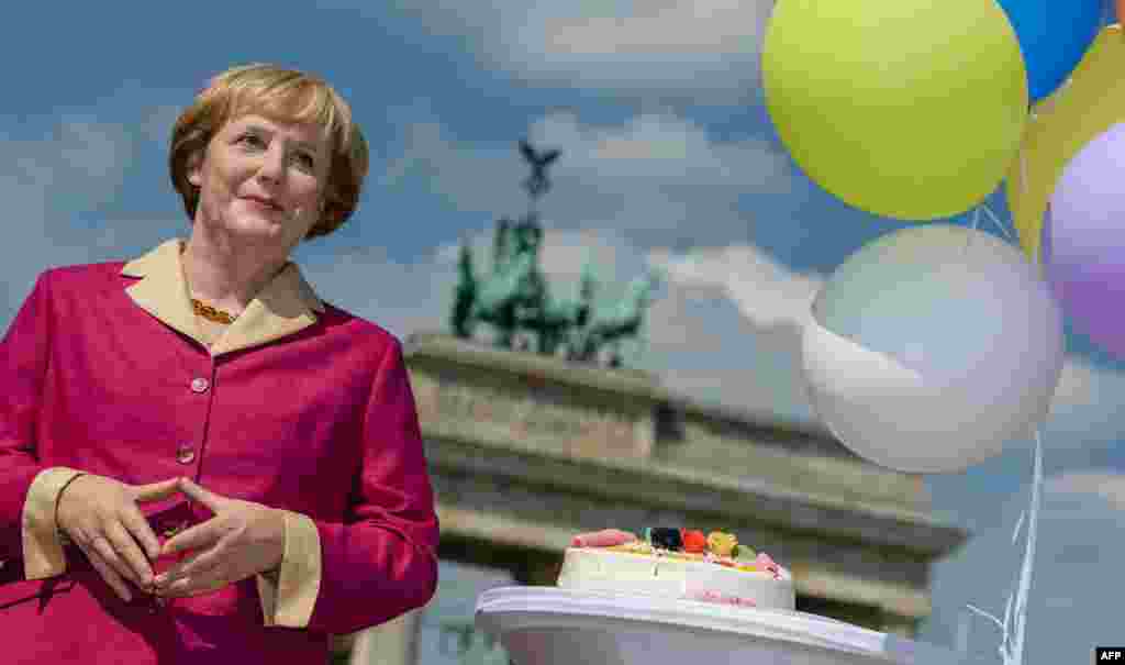A wax likeness of German Chancellor Angela Merkel pictured in front of the Brandenburg Gate in Berlin on the occassion of her 60th birthday.