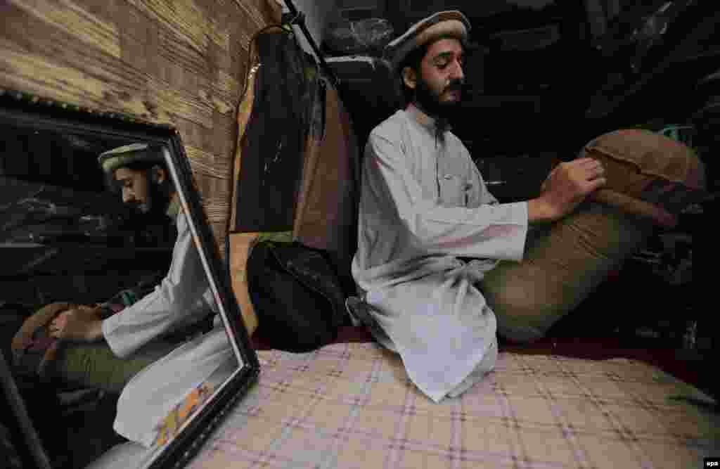 A tailor stichtes traditional Chitrali caps as winter season begins in Peshawar, Pakistan. (epa/Bilawal Arbab)