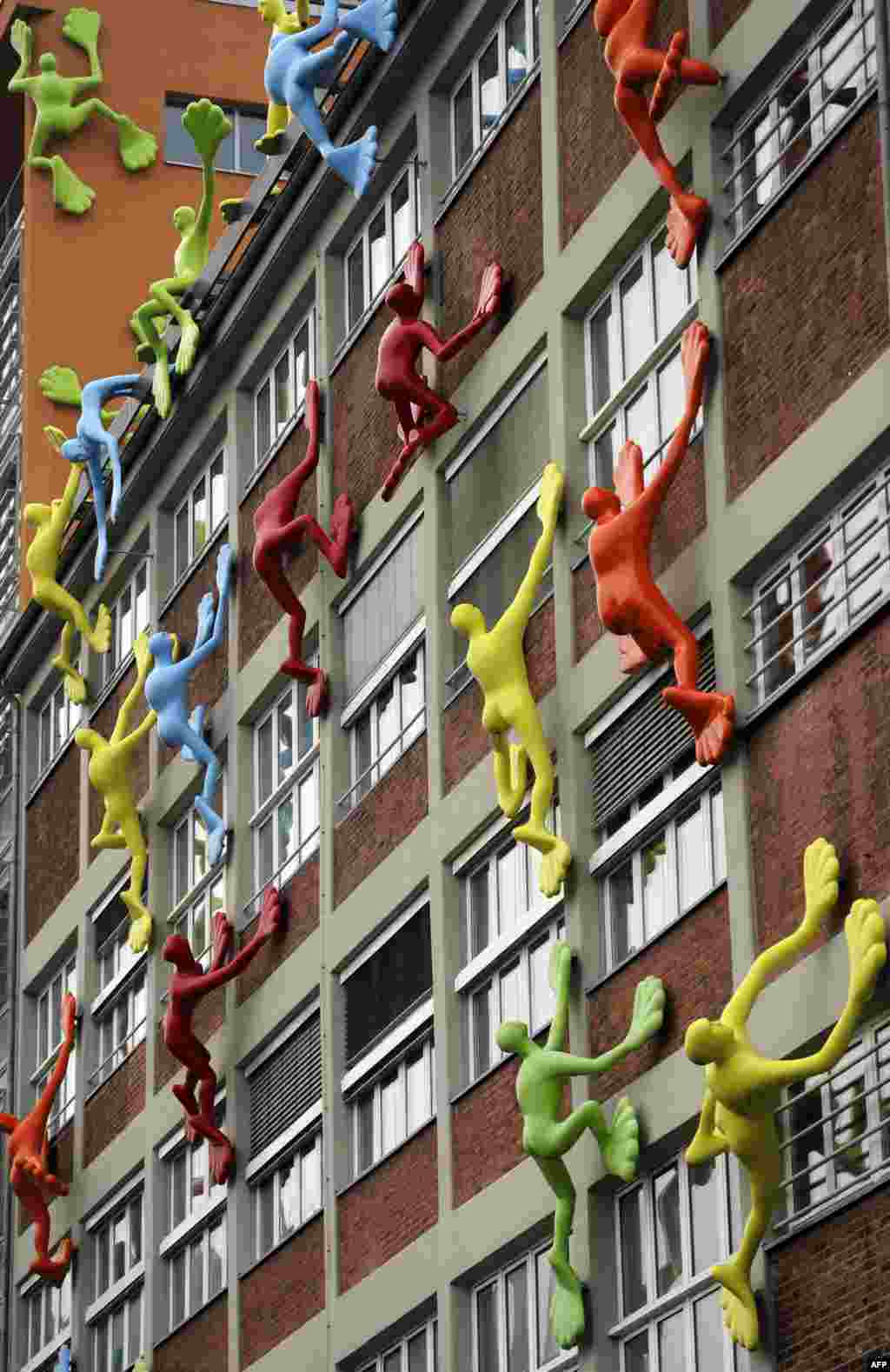 Sculptures called &quot;Flossis&quot; by German artist Rosalie seem to climb a building in Duesseldorf in western Germany. The installation consists of 29 sculptures. (AFP/Marius Becker)