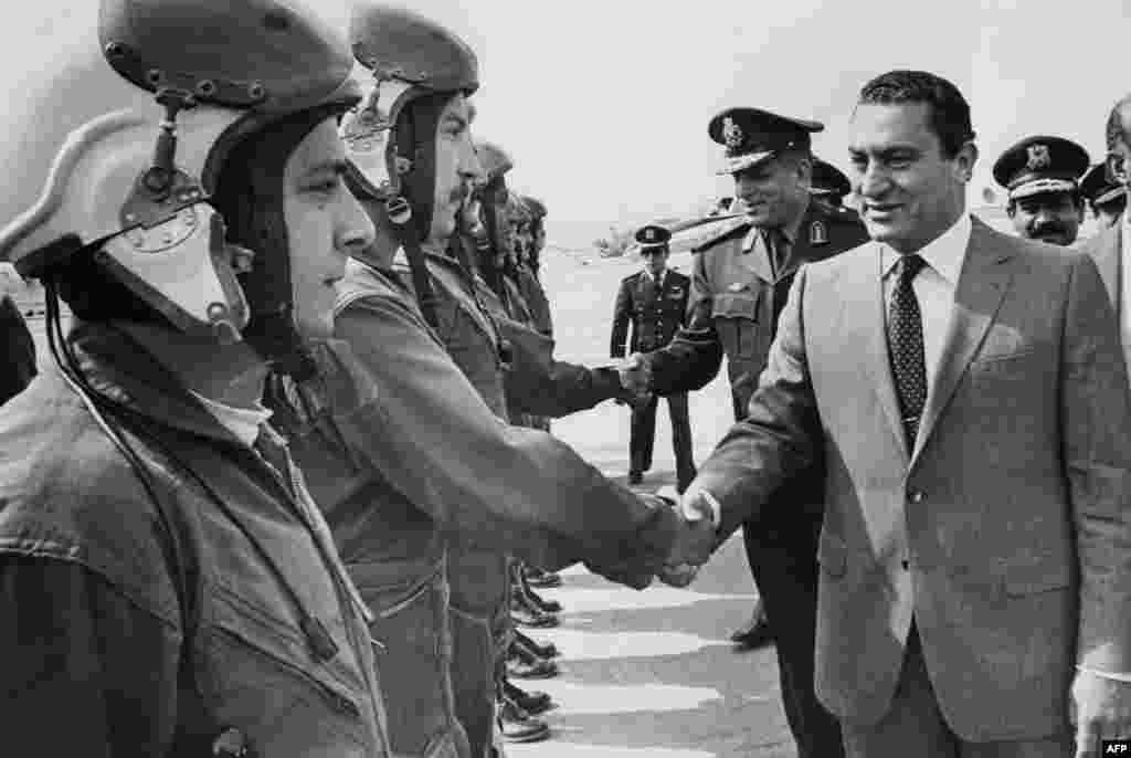 Mubarak shakes hands with jet pilots in April 1991. - Mubarak joined the Air Force Academy in 1950 and received instruction in the Soviet Union, moving up the chain of command from pilot to instructor to squadron leader to base commander. He was appointed director of the Air Force Academy and chief of staff of the Egyptian Air Force during the War of Attrition between Egypt and Israel (1967-72) and by 1973 had been promoted to the rank of air chief marshal.