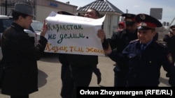 Ресей елшілігі алдында наразылық танытқан Астана тұрғыны Мұратбек Арғынбековті (ортада) полиция әкетіп бара жатыр. 14 сәуір 2014 жыл.