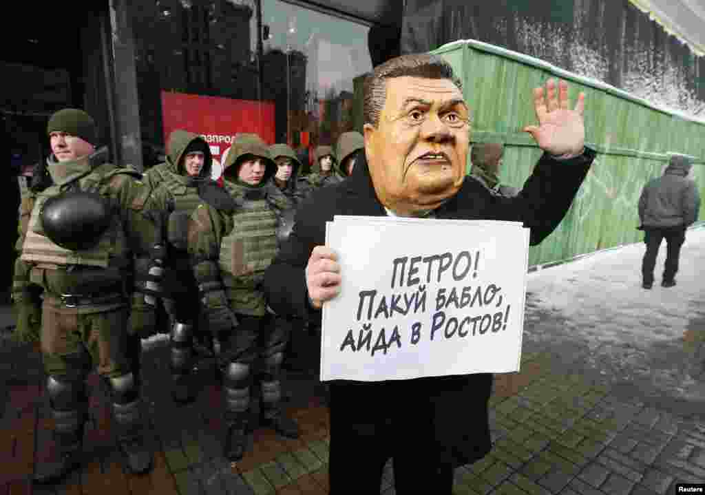 УКРАИНА - Поддржувач на поранешниот грузиски претседател Михаил Саакашвили со маска на поранешниот украински претседател Виктор Јанукович, на протест пред Судот во Киев во кој му се суди на Саакашвили. Лидерот на украинската партија Движење на новите сили, Михаил Саакашвили, во судница изјави дека се смета за воен заробеник, а не за уапсен. Тој беше уапсен под сомнение за помагање на криминална организација, а по неговото апсење во Украина постојано се организираат протести од неговите приврзаници.