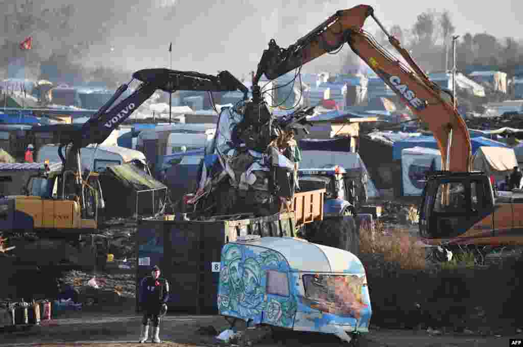 A demolition crew works to dismantle the migrant camp known as &quot;The Jungle&quot; in Calais, northern France, on October 2. Some 6,000-8,000 people had been living there in dire conditions. (AFP/Philippe Huguen)