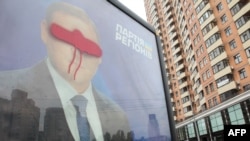 A billboard for Mykhaylo Dobkin is shown defaced in Kyiv in May. Dobkin's brother, Dmytro, is one of those named as a suspected vote buyer.