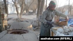 Женщина печет хлеб в тамдыре. Туркменистан (архивное фото)