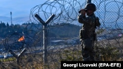 Një pjesëtar i sigurisë duke kontrolluar kufirin mes Maqedonisë së Veriut dhe Greqisë.
