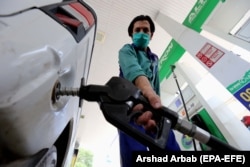 A gas station attendant fills a car's tank in Peshawar.