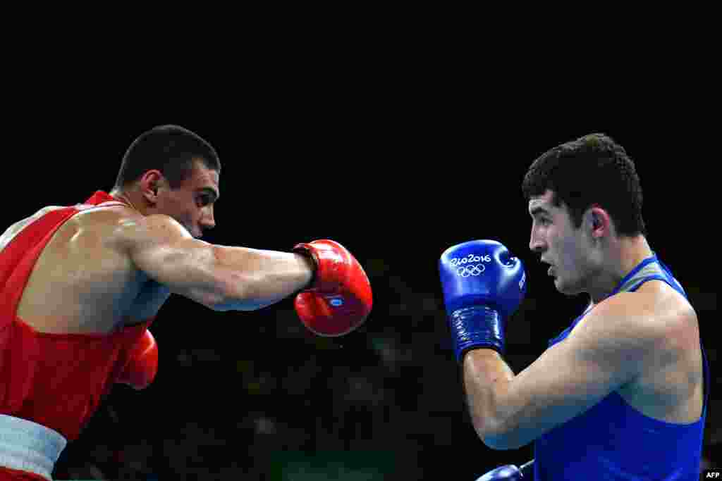 Uzbekistan's Rustam Tulaganov (right) blocks a punch by Russia's Yevgeny Tishchenko during a men's heavy (91-kilogram) semifinal.