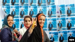 Женщины рядом с плакатами с предвыборной агитацией. Кередж, 22 февраля 2016 года.