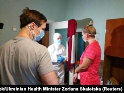 Міністр охорони здоров'я України Зоряна Скалецька у захисному костюмі та масці розмовляє з евакуйованими з Китаю в санаторії в селі Нові Санжари Полтавської області, 24 лютого 2020 року