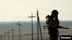 Ukraine -- A Ukrainian soldier stands guard outside a Ukrainian Army military camp set up on a field close to the Russian border in east Ukraine, March 24, 2014