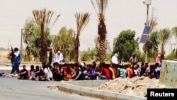 ISIL gunmen with captured police in the Iraqi city of Tikrit on June 12, 2014. 