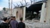 Security force and civilians gather near the burned Iranian consulate in Najaf, Iraq, Thursday, Nov. 28, 2019. An Iraqi police official says anti-government protesters have burned down the Iranian consulate in southern Iraq late Wednesday(AP Photo/Anmar K