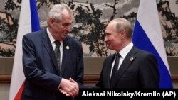 Zeman and Putin shake hands on the sidelines of a summit in Beijing in 2017. Zeman says Russia's aggression in Ukraine has been "a cold shower" for him in his approach to Moscow.