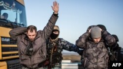 Пророссийские боевики проводят досмотр на контрольно-пропускном пункте Чонгар, блокирующем въезд в Крым, 10 марта 2014 года