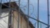 Вид на тюремное здание через решетку. Иллюстративное фото. 