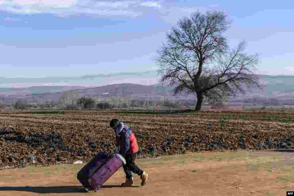 A boy pushes a suitcase as he walks with other migrants and refugees after crossing the Macedonian border into Serbia near the village of Miratovac. (AFP/Armend Nimani)