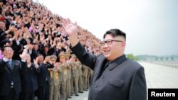 Лидер Северной Кореи Ким Чен Ын приветствует сограждан после испытания ракеты средней дальности.